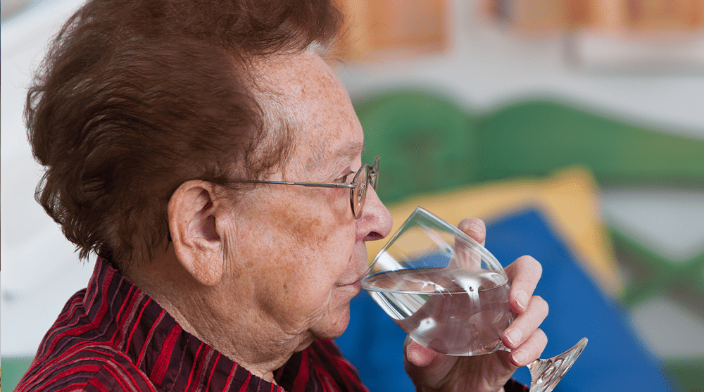 Elderly woman drinking water from a glass