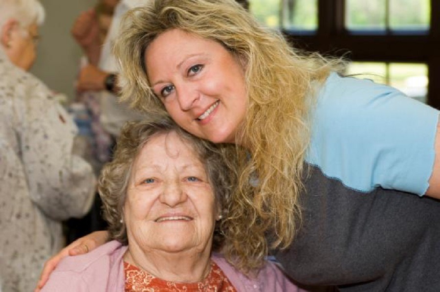 Elderly women poses with her healthcare worker