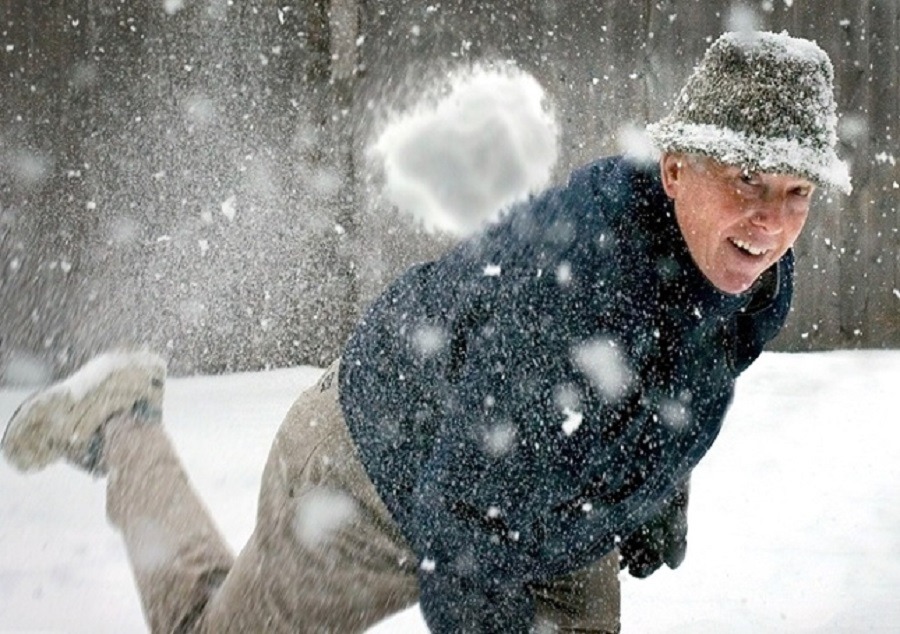 Senior man throws snowball