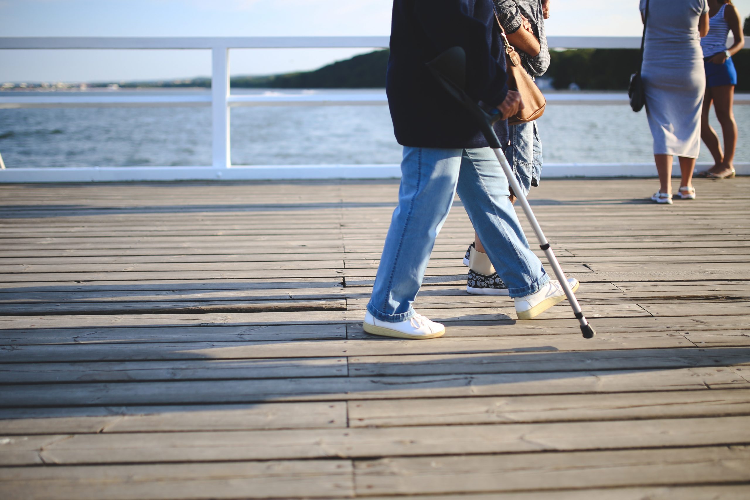 Man walking on pier with cane