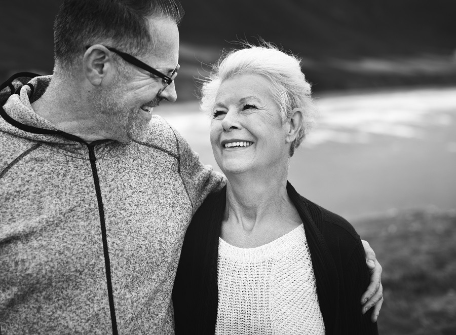 Women smiling up at man while walking together