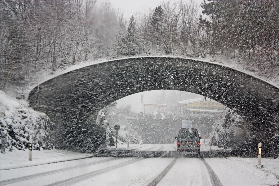 Car driving under bridge in winter