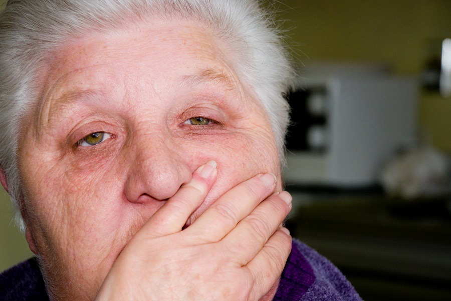 Concerned senior with hand over mouth