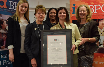 A group of VHA staff posing with an award