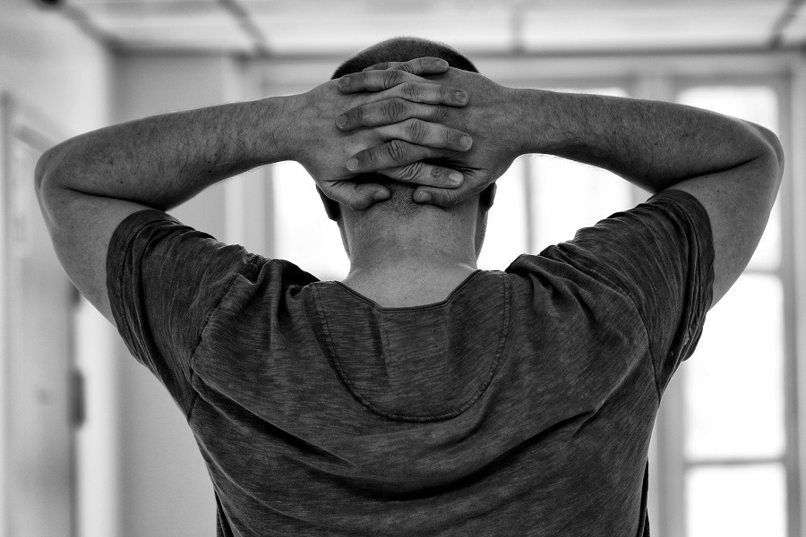 Man holding the back of his head