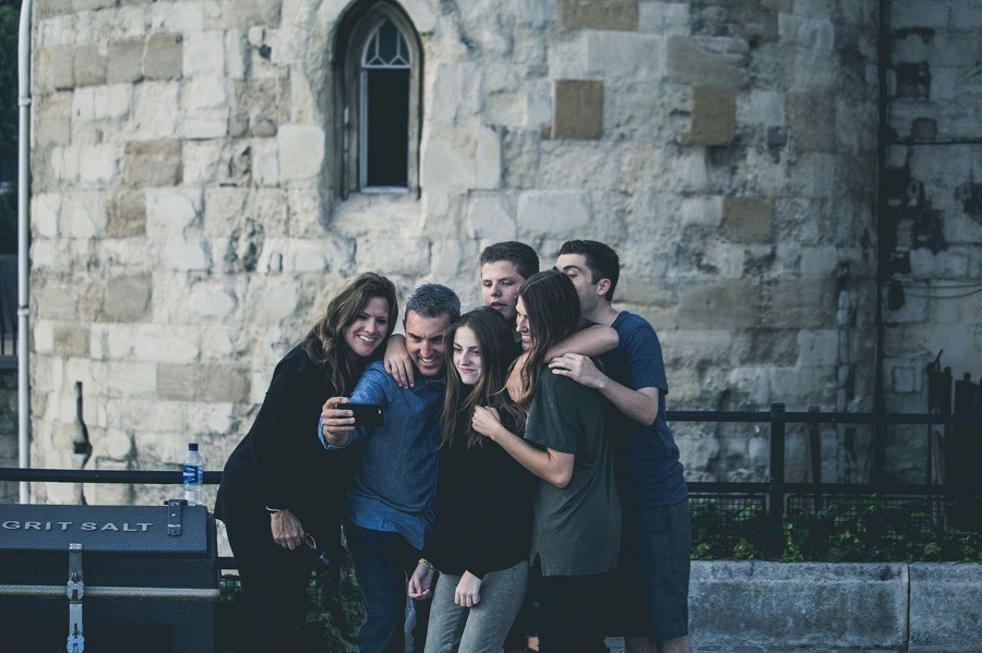 Family pose together for a picture in front of a tourist location