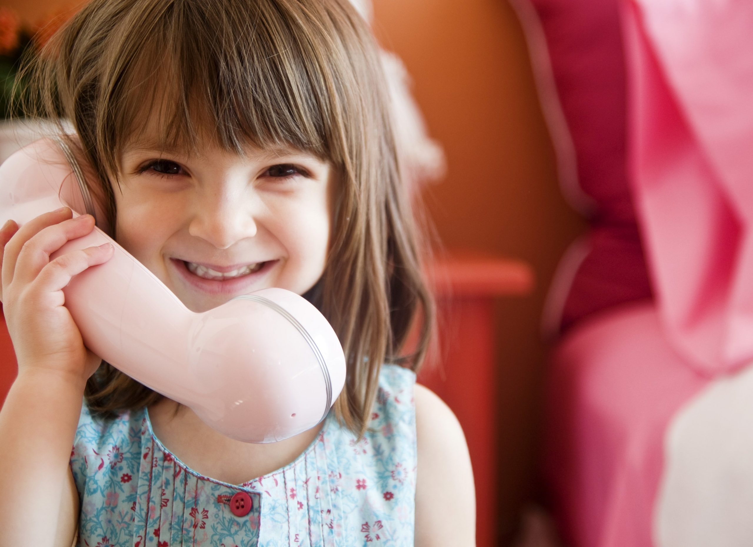 Toddler holding a toy phone to her ear