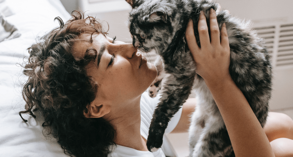 Women cuddles with her cat in her bedroom