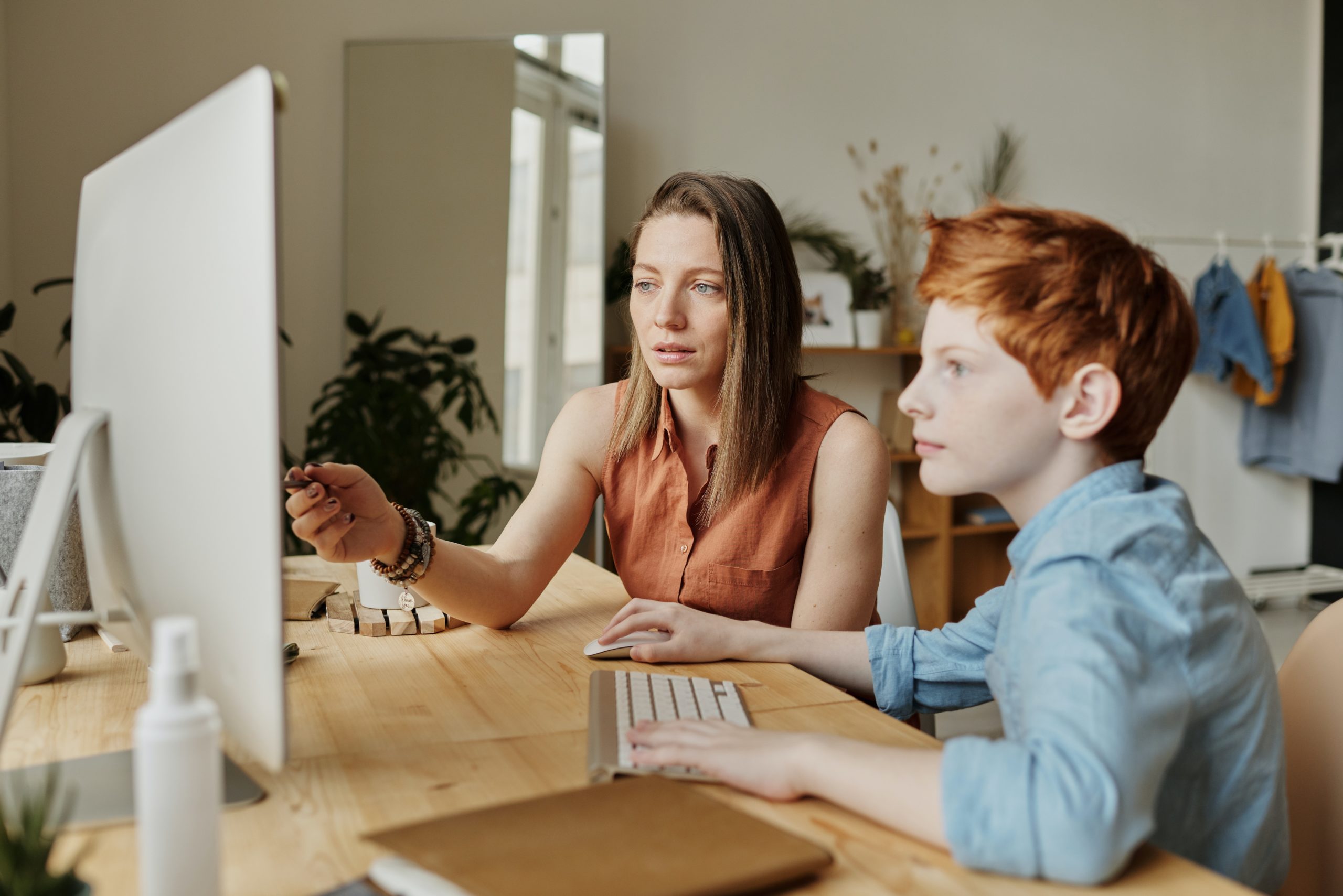 Son and his mother sitting in front of a computer