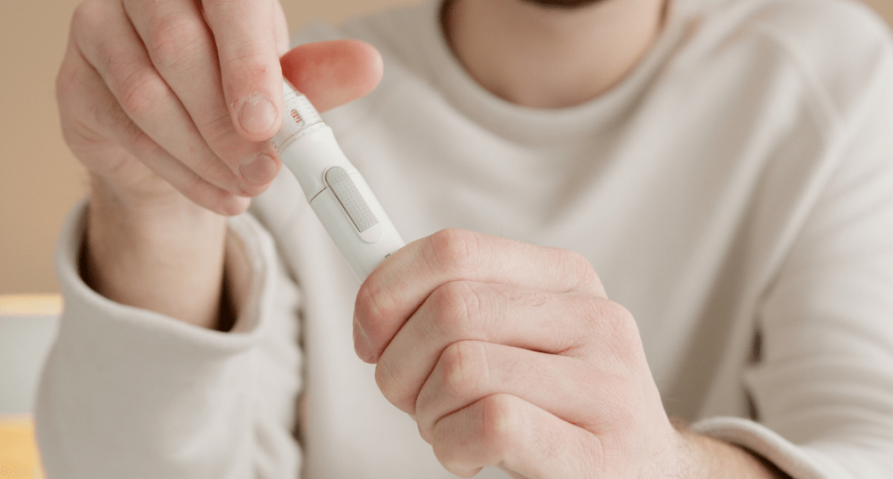 Man is white shirt holding diabetic tool