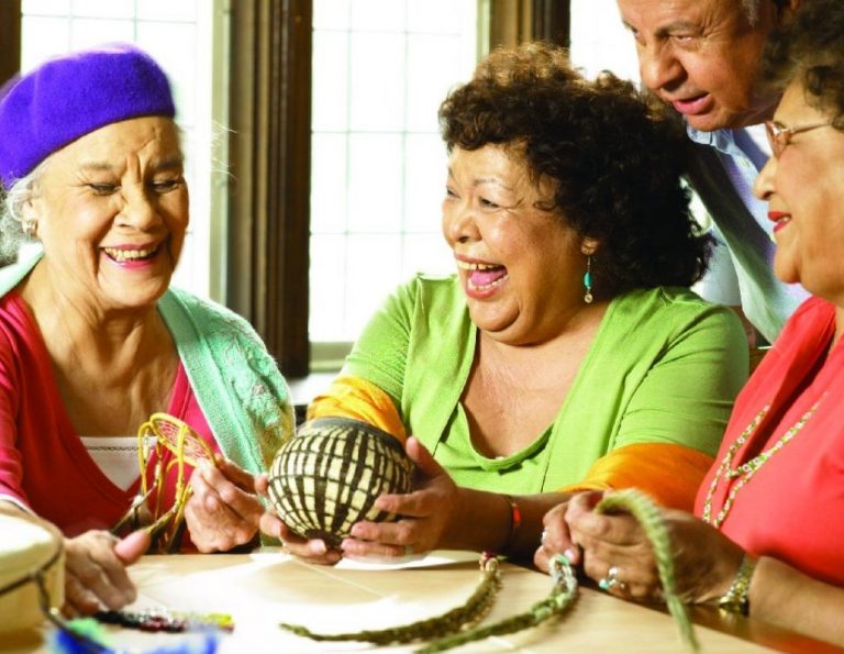 Seniors laughing around a table, doing an activity