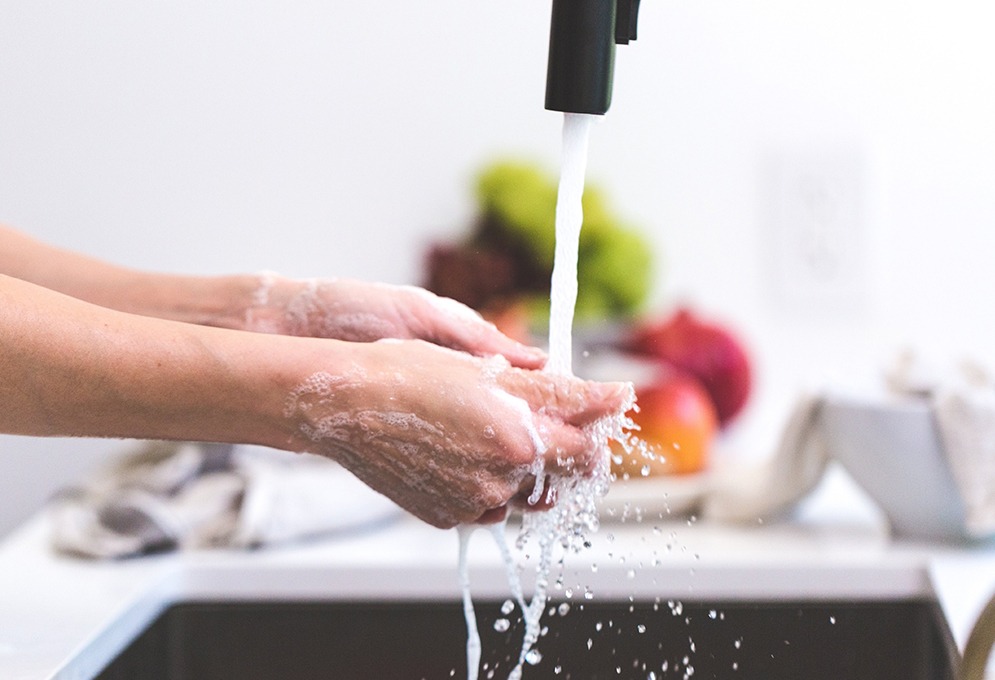 Person washing hands in kitchen