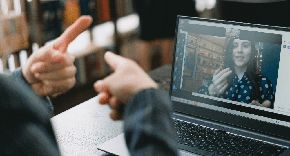 Two young women using sign language over video conversation