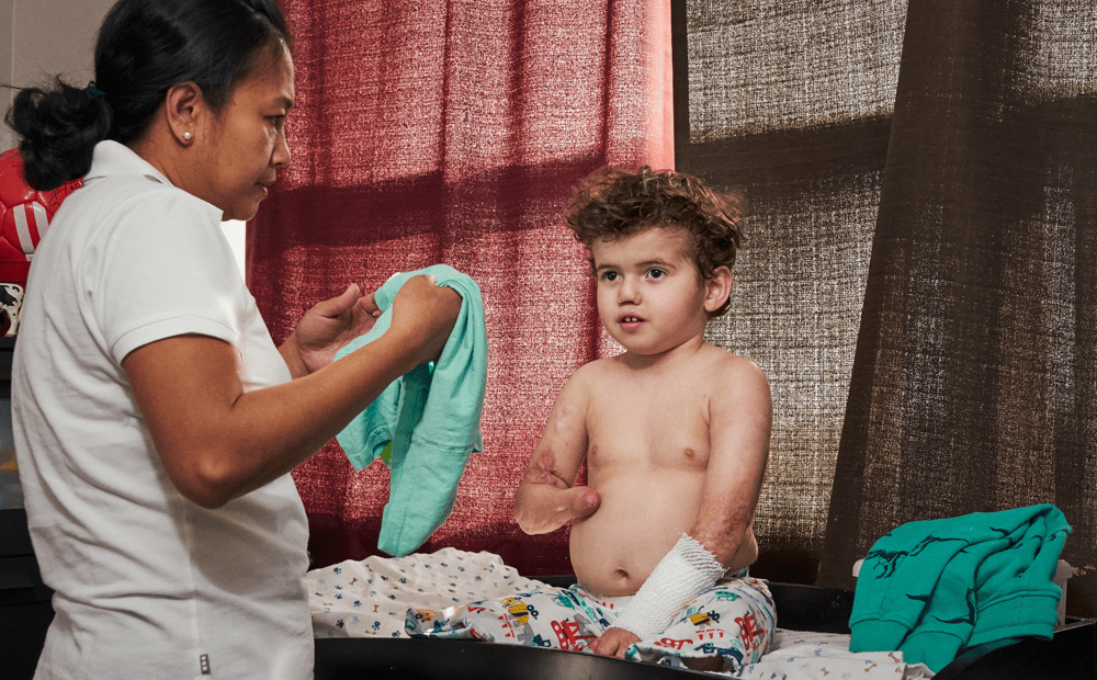 A Personal Support Worker helps dress a paediatric client
