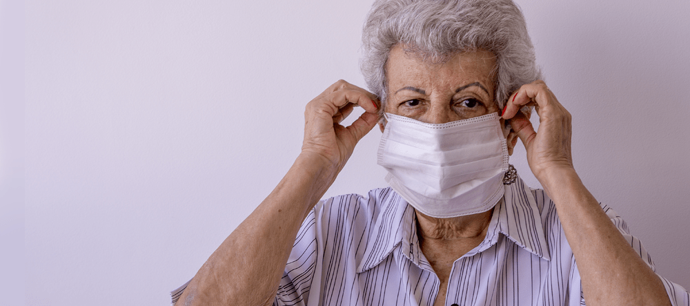 Elderly women puts on face mask