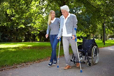 Woman helping a senior to walk