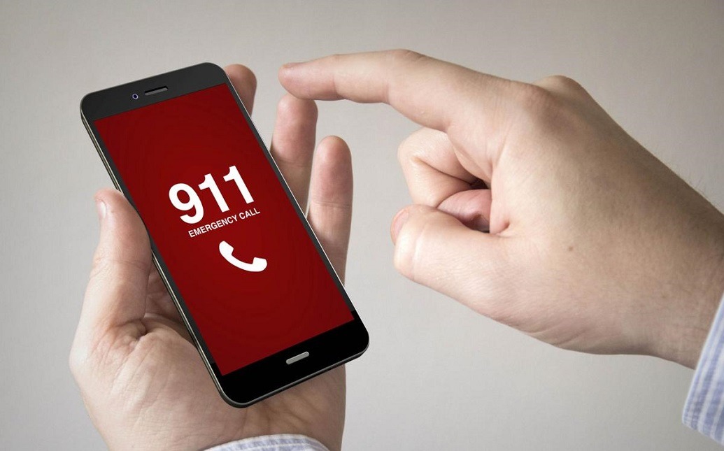 Hand holding a phone that says "911 Emergency Call"