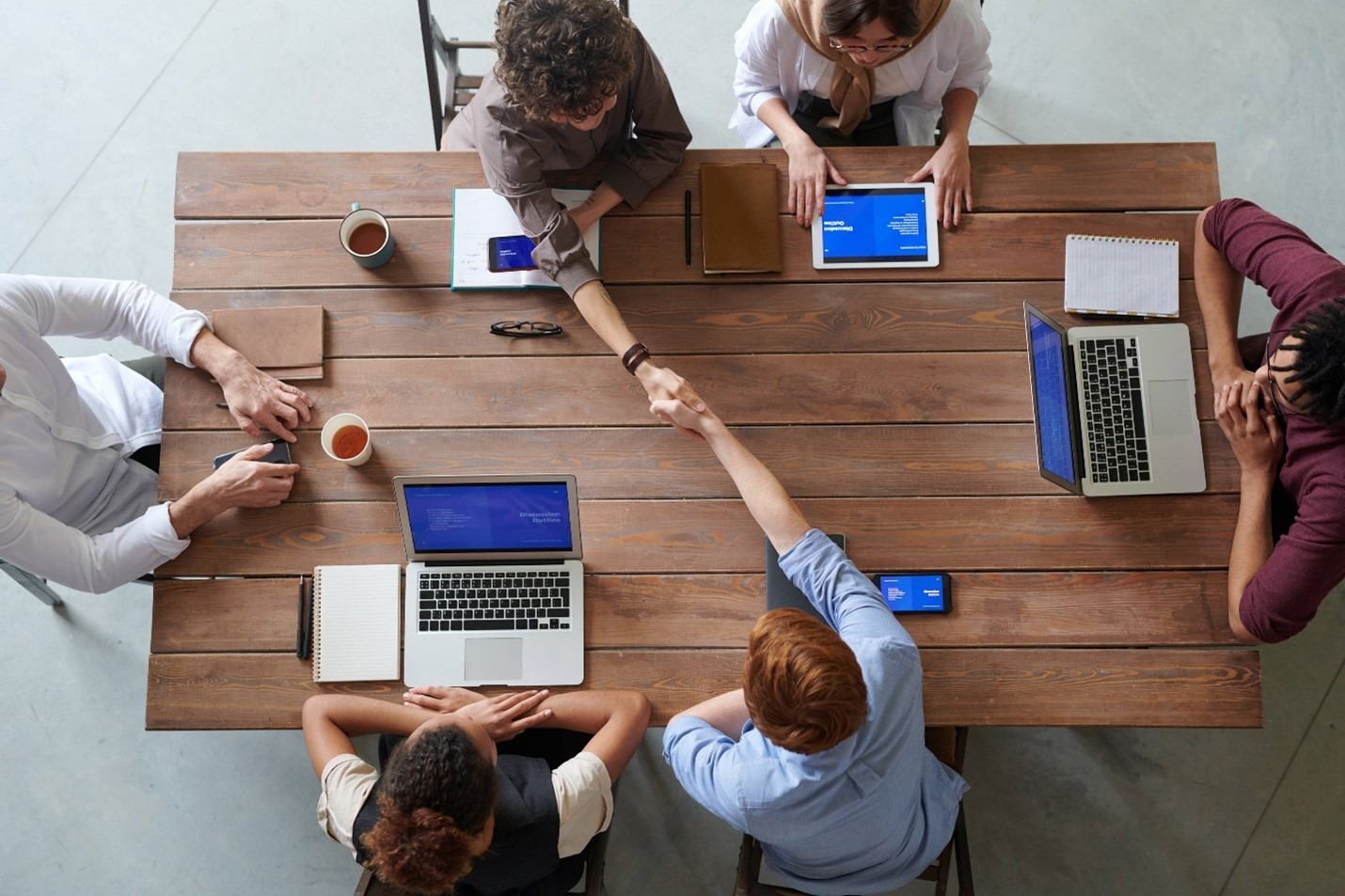 A group of people with laptops around a table