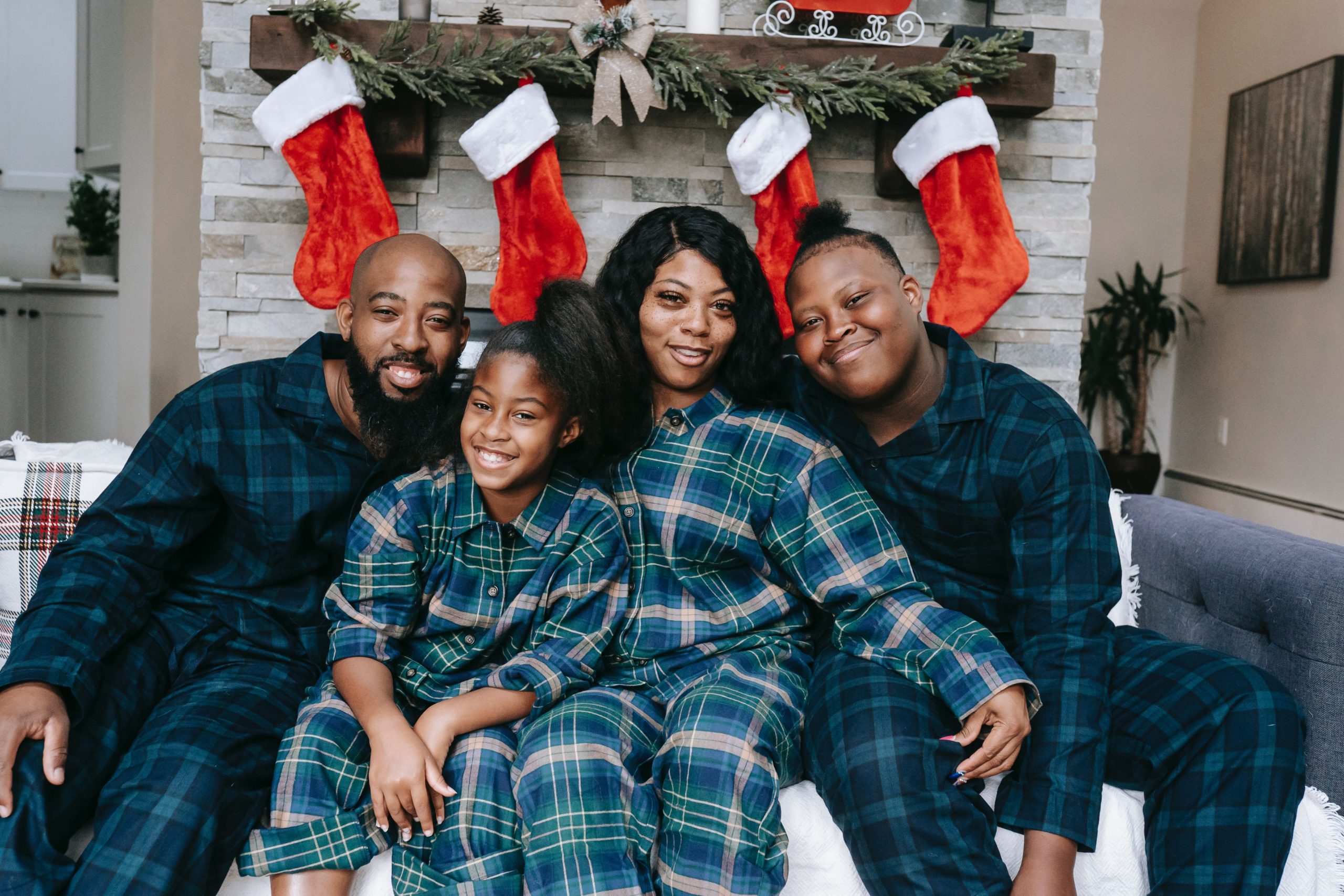 Smiling family sitting together, wearing matching pajamas