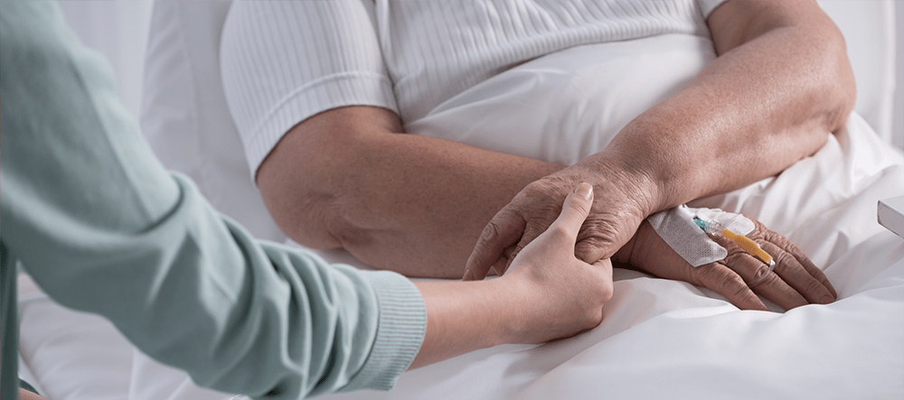 Palliative patient holding hand for support