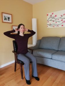 Woman with both hands on her head, facing forward