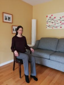 Woman sitting on a chair with one leg raised slightly