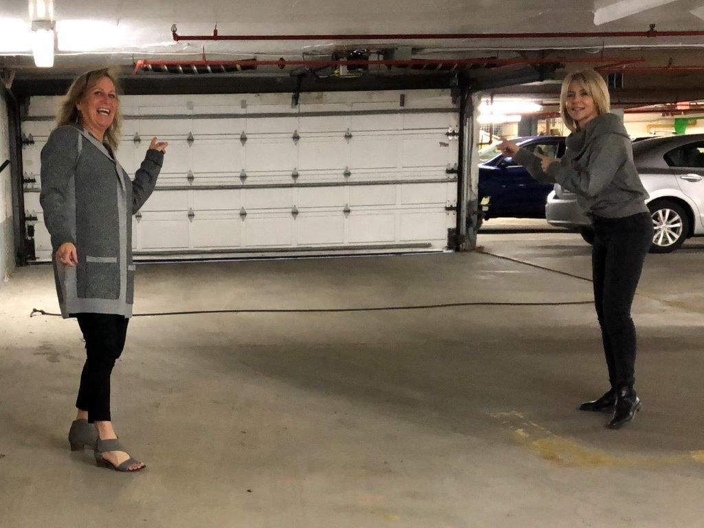 Kathryn and Patti standing in front of a closed parking lot garage door