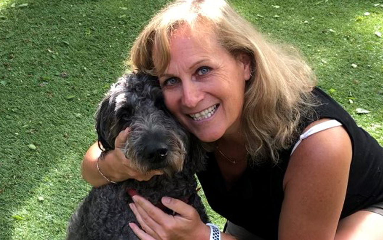 Dr. Kathryn Nichol, smiling and posing with her dog