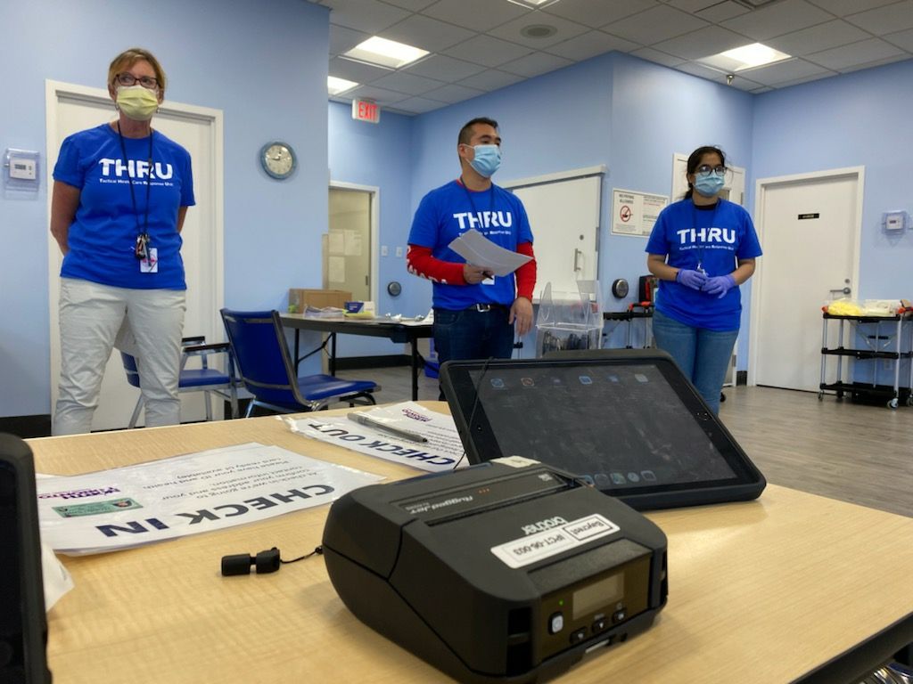 Three members of the VHA THRU Team stand, socially distanced, at a clinic