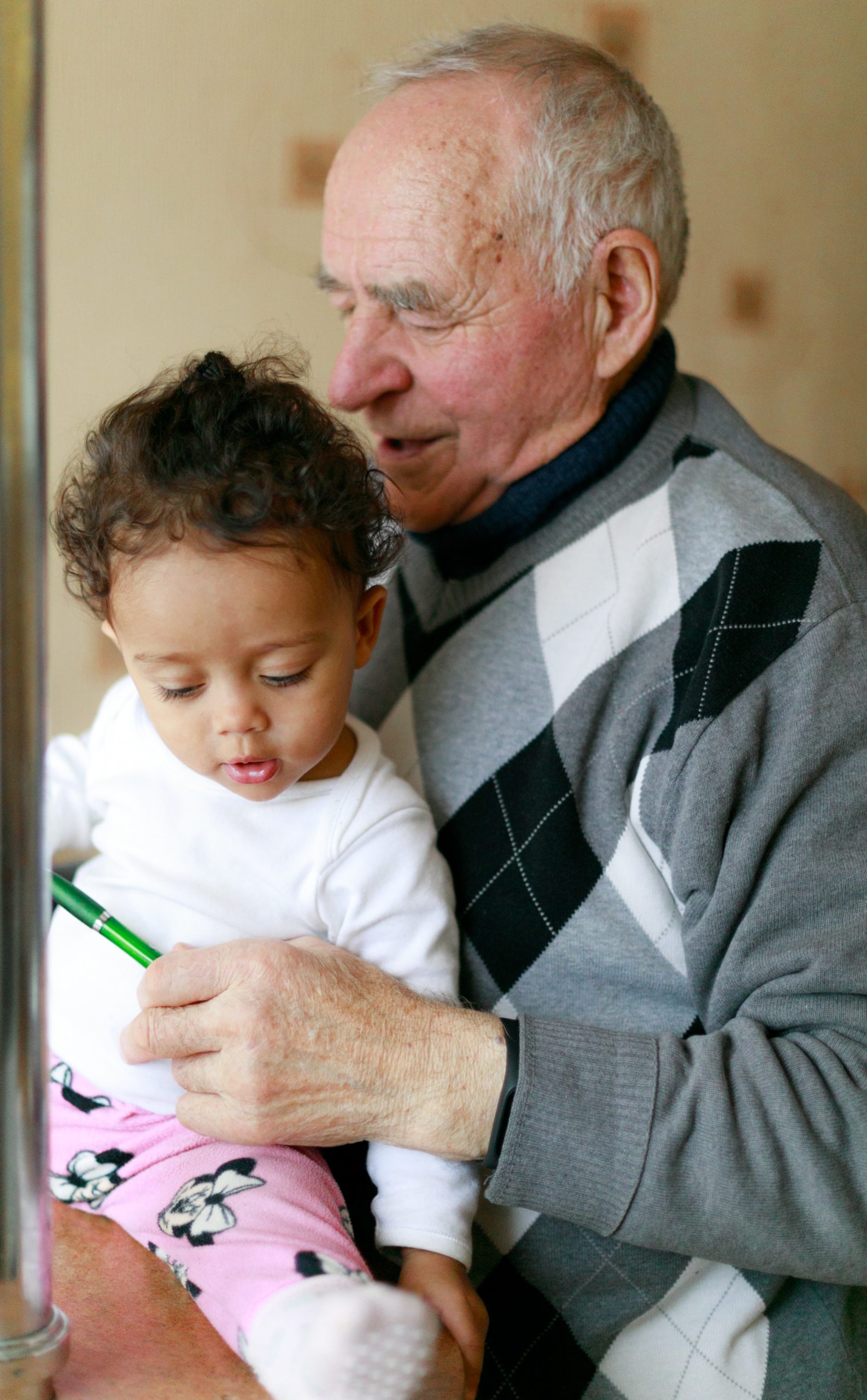 Elderly man carrying a young child