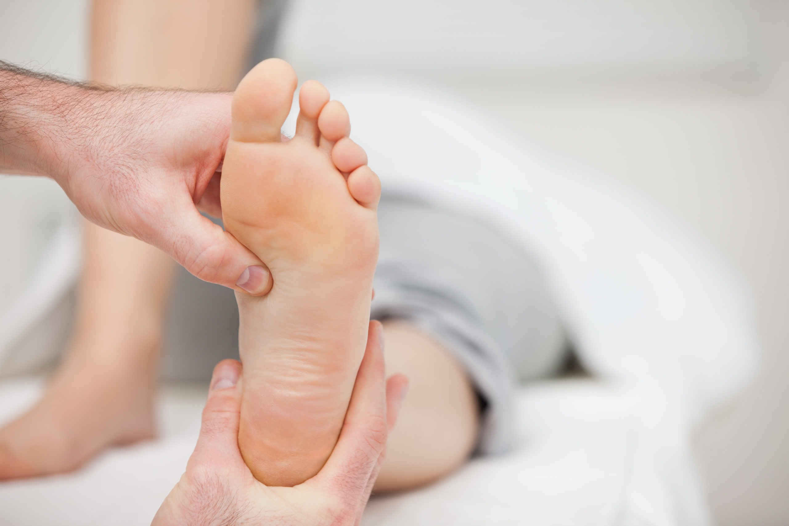 Doctor holding the foot of a woman in his office