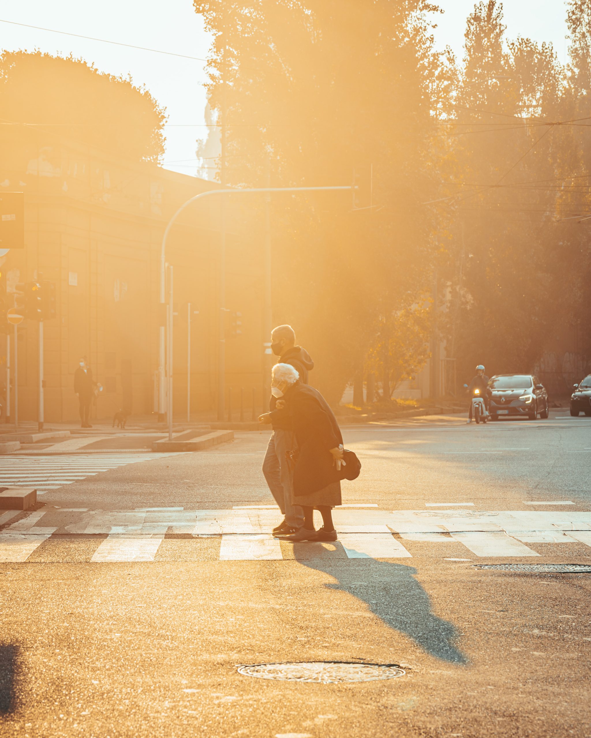 Caregiver helping elderly woman cross the street