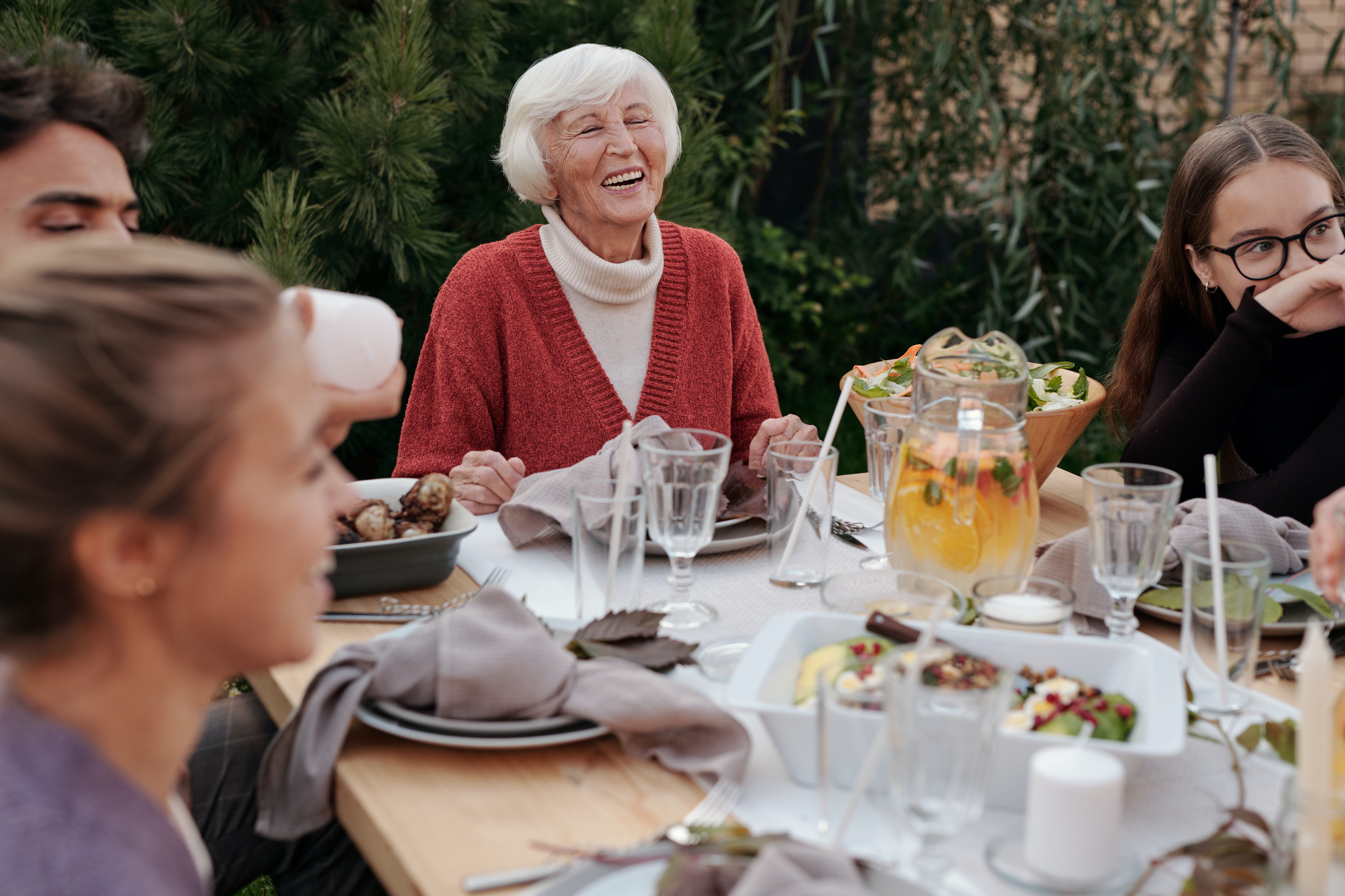 Older woman shown having a meal with her family