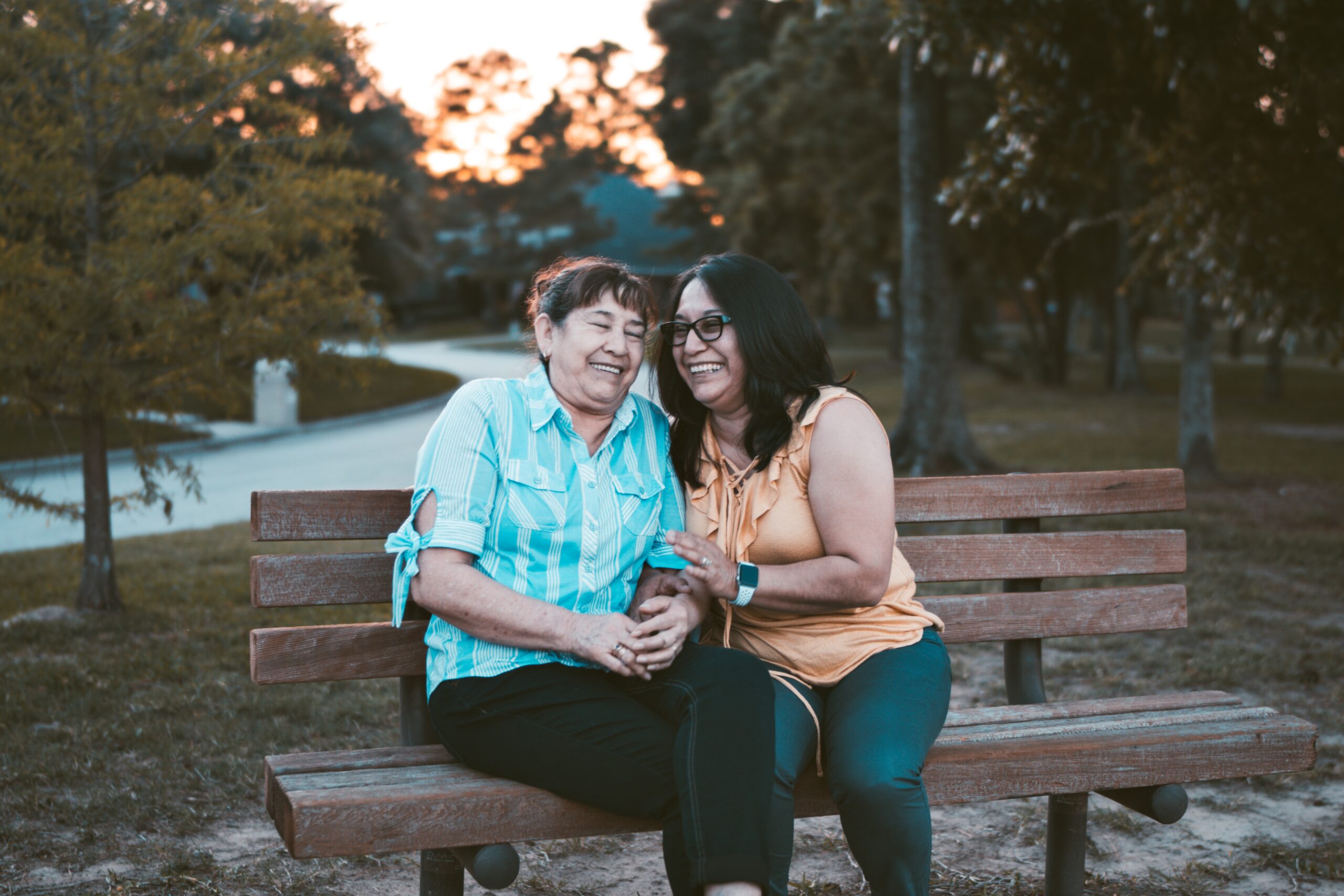 senior mother and daughter on a park bench