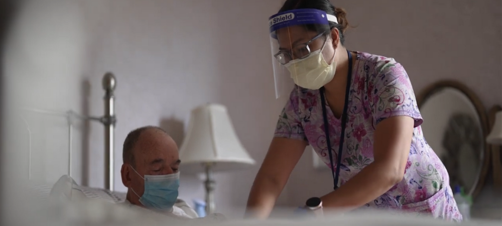 Nurse caring for patient in bed