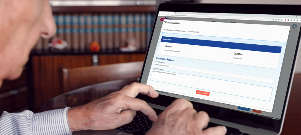 Elderly man sits at desk and types on keyboard as he interacts with the myVHA client portal website