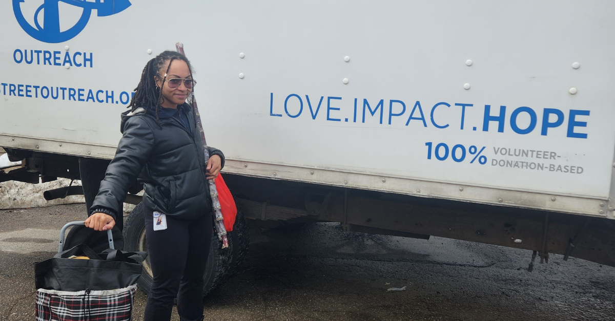 PSW Kaila Jonsen poses in front of a truck that reads "Love. Impact. Hope".