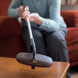 Senior women using reacher arm to get glasses case