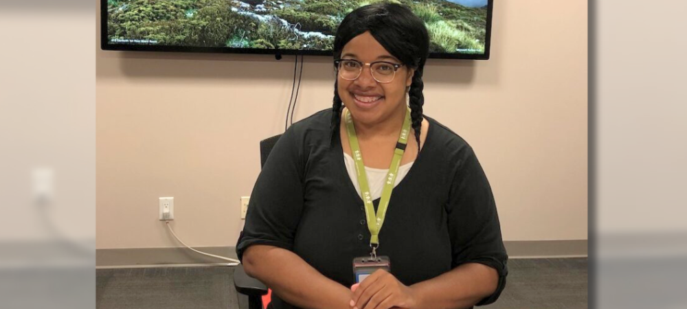 Social worker, Jhenelle Grey, poses for photo while sitting at desk in office.