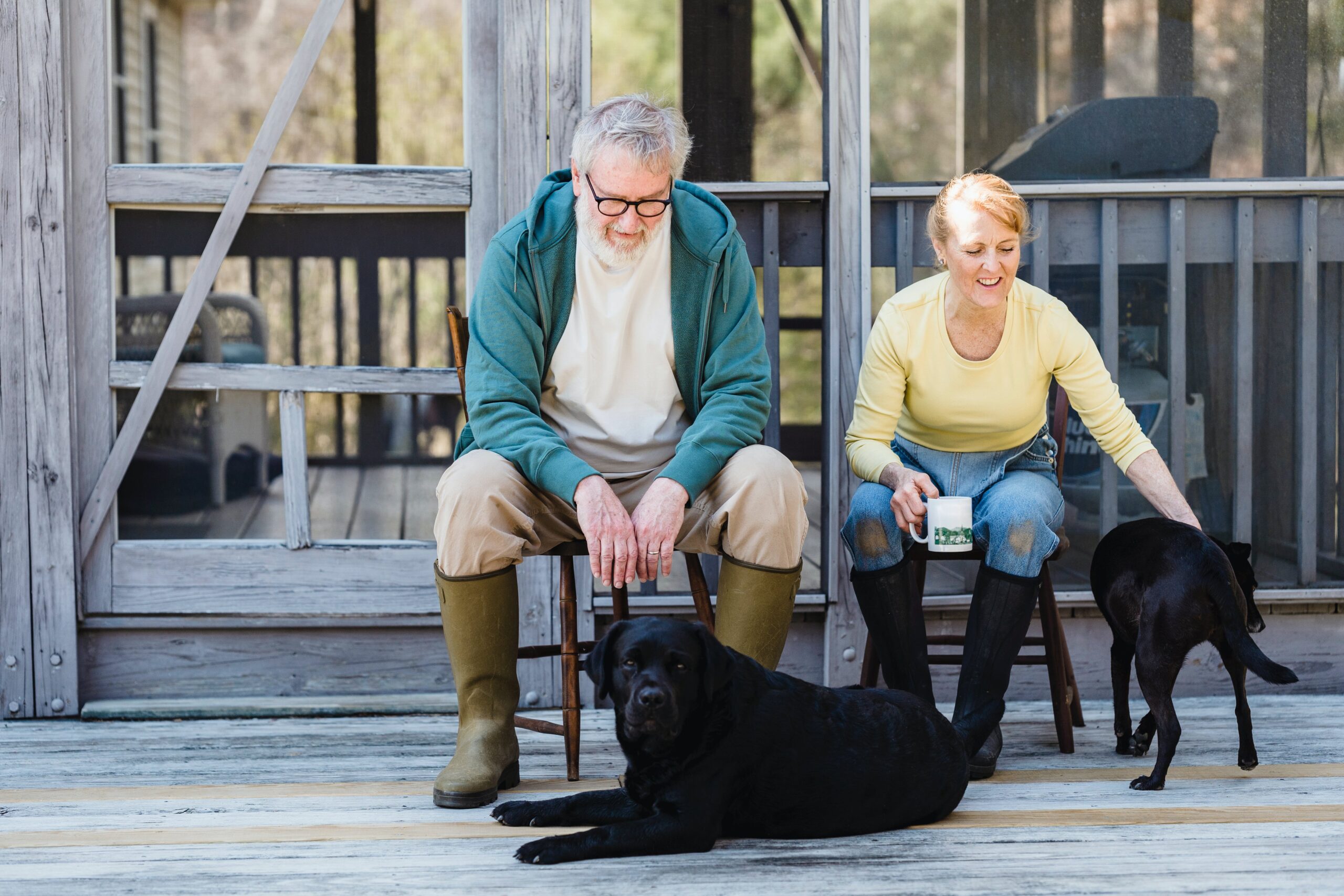 Man and woman on porch with dogs