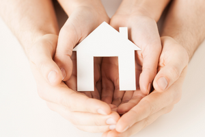 hands wrapped around a house