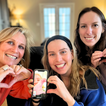 Dr. Kathryn Nichol poses with her family, their hands in a shape of hearts.