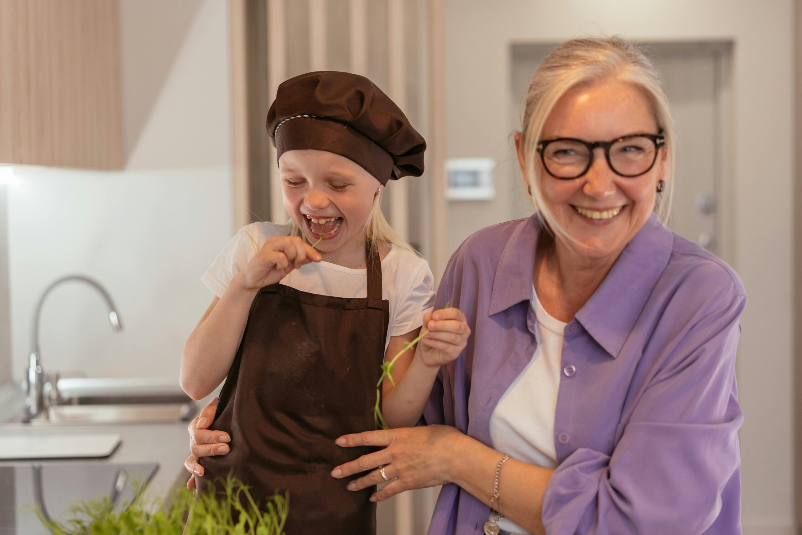 older woman cooking with young child