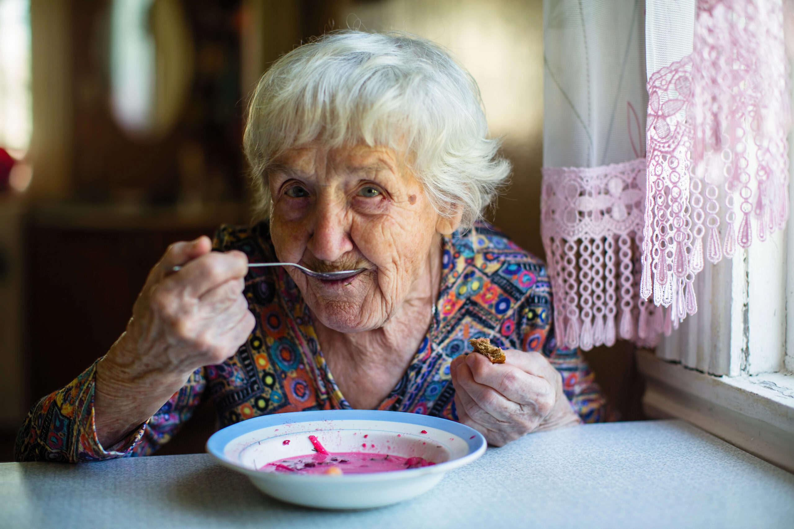 Older woman eating soup with a spoon