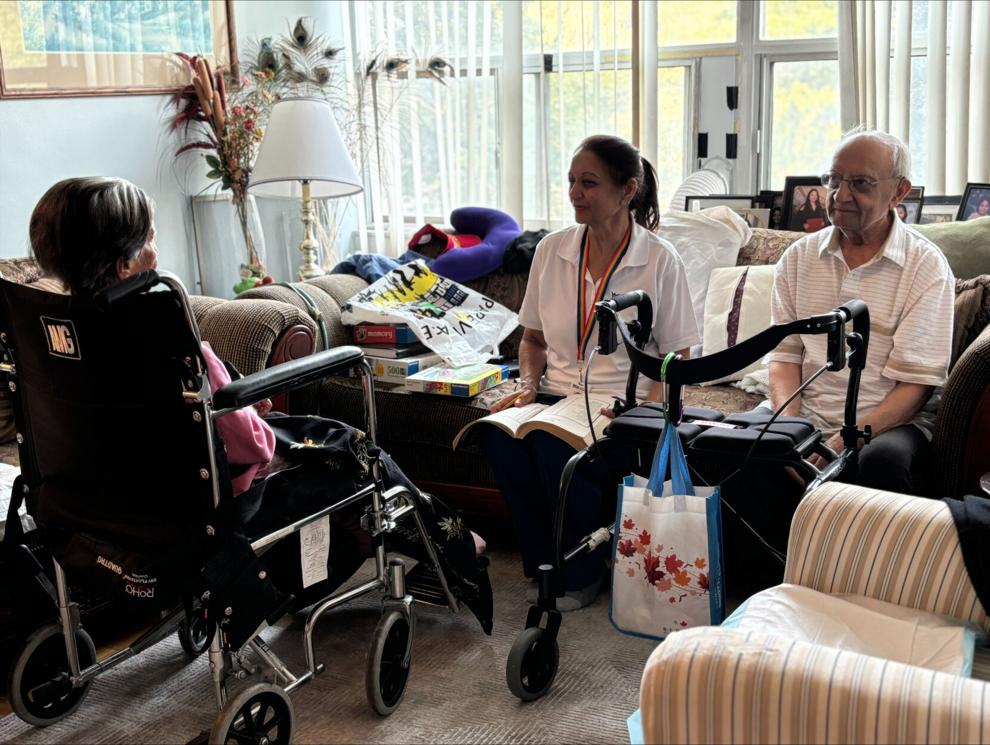 A Personal Support Worker cares for a husband and wife in their apartment.