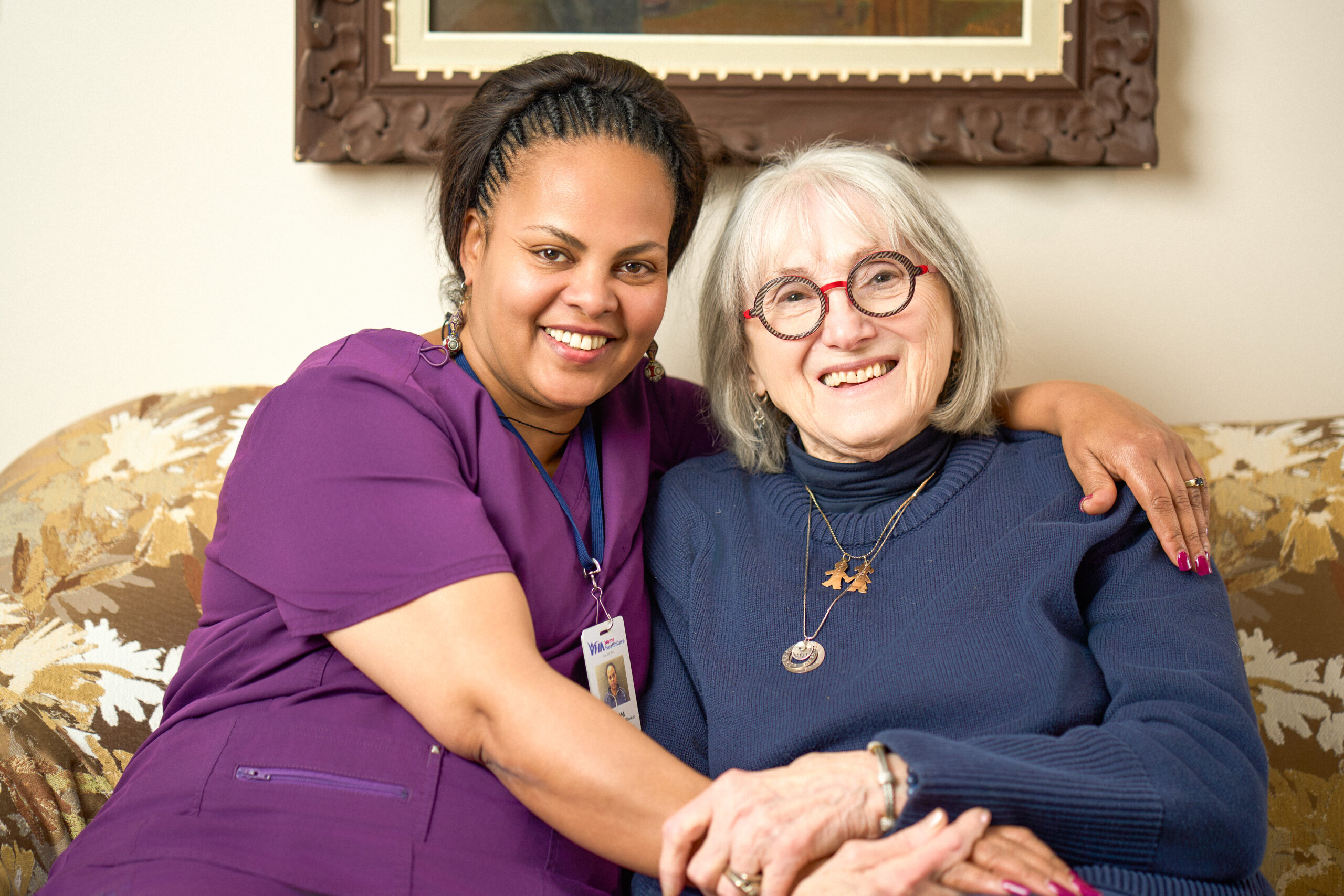 Bella and PSW, Selam, sitting together on a couch embracing.